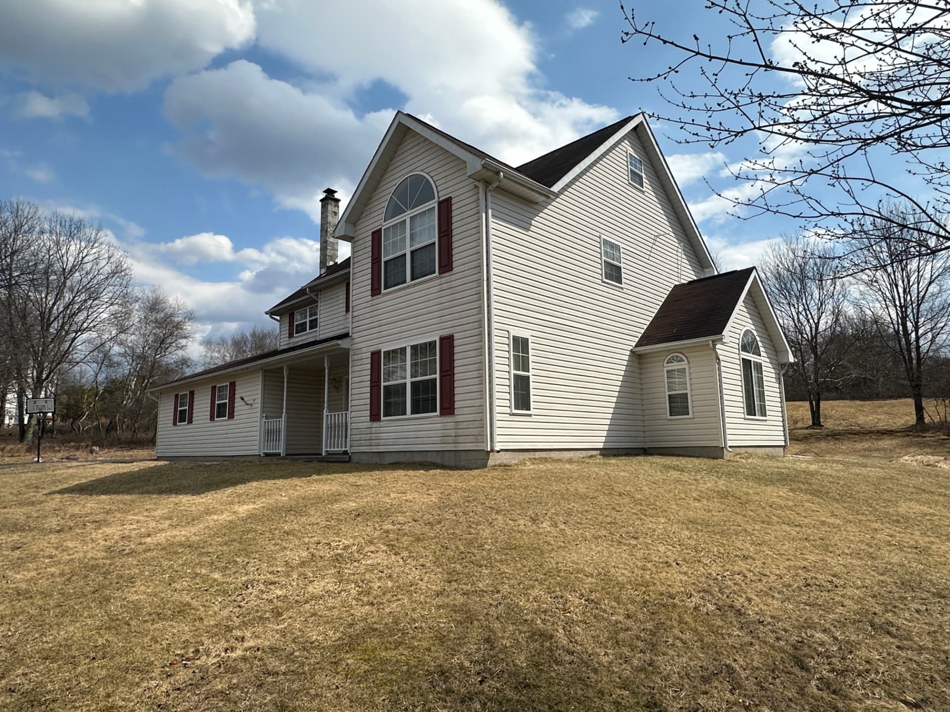 Front and side exterior view of a two story Pocono home with a covered porch