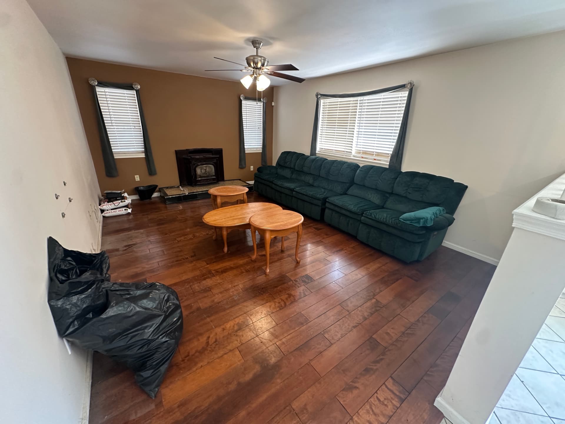 Living room with hardwood flooring, a fireplace insert, and bay window