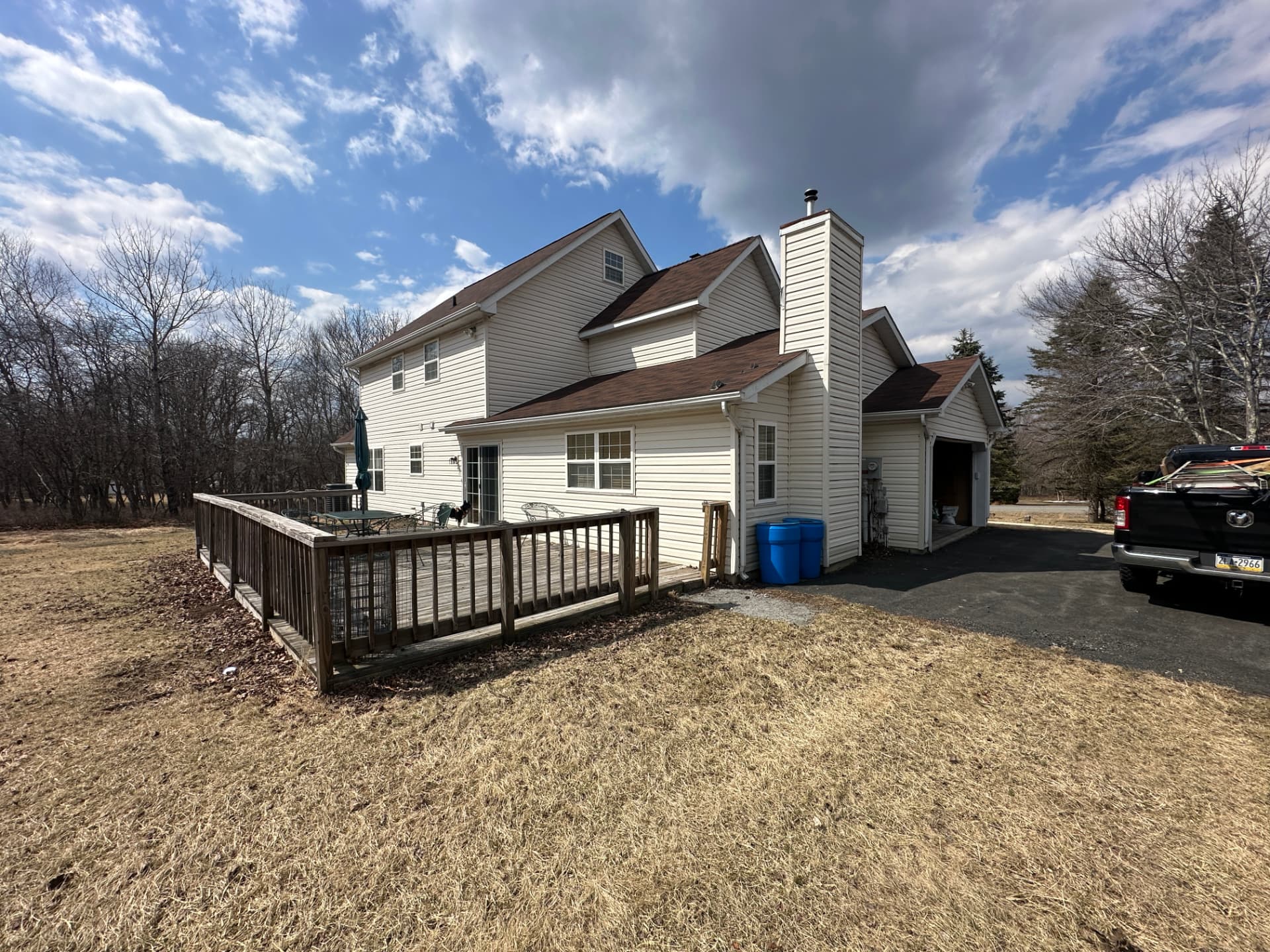 Rear exterior view of the home showing a wooden deck and attached garage