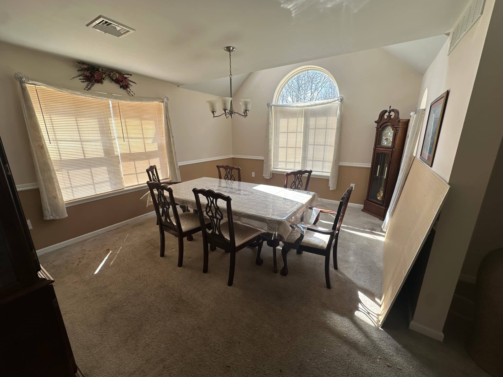 Dining room with a bay window, arched window, and carpeted floor